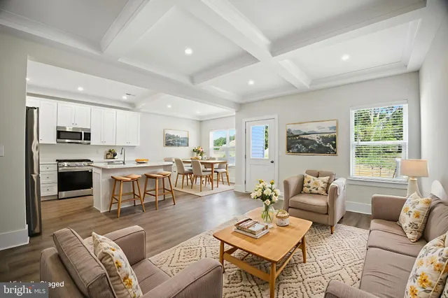 a living room with furniture kitchen view and a window