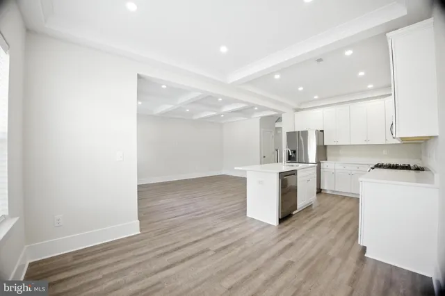 a kitchen with a refrigerator and white cabinets