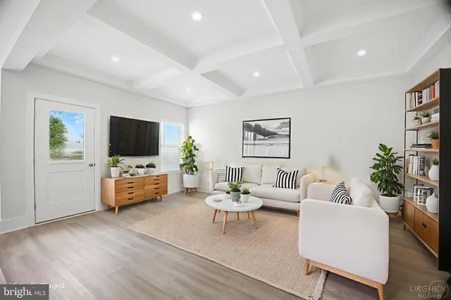 a dining room with furniture potted plants and wooden floor