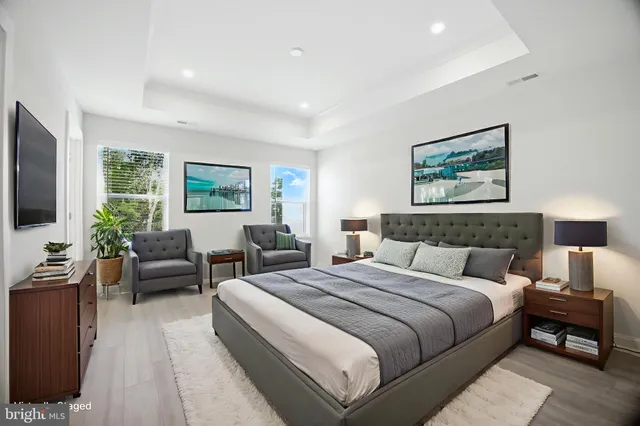 a spacious bedroom with a bed and a potted plant