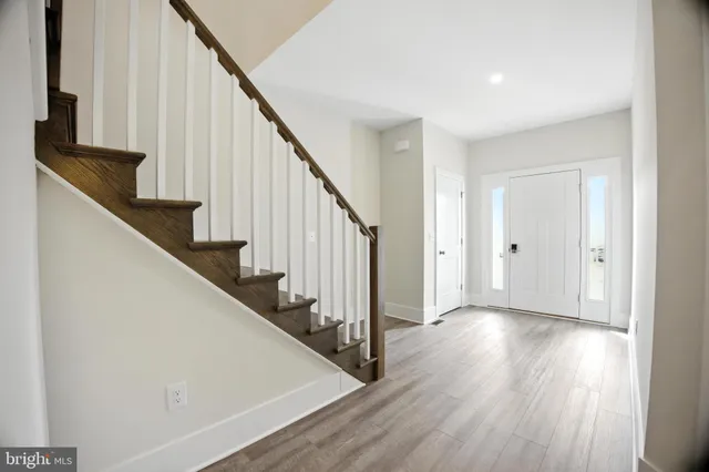 a view of staircase with wooden floor and white walls