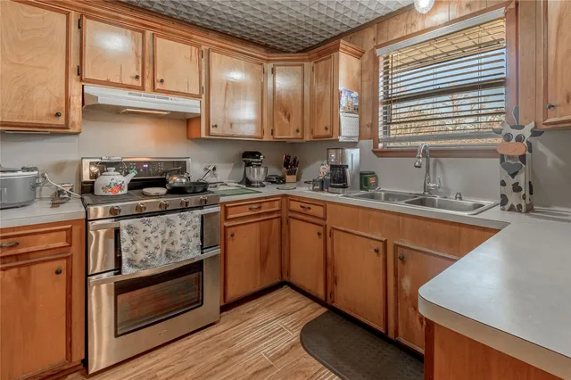 a kitchen with stainless steel appliances granite countertop a sink a stove and a refrigerator