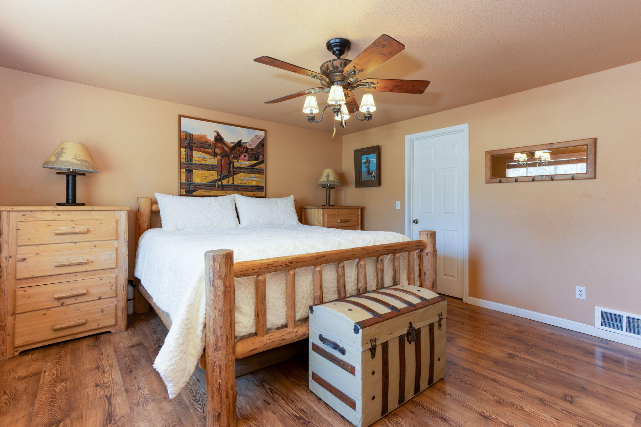 19450 Calico Road Bend, OR 97702 - Photo 17 of 41 a bedroom with a bed and a chandelier