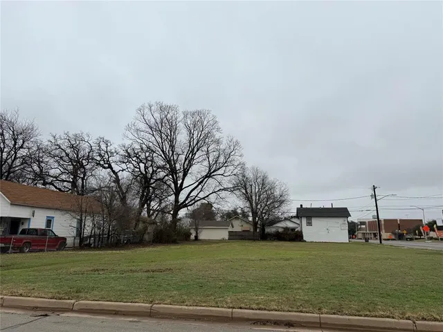 a view of a big house with a big yard and large trees