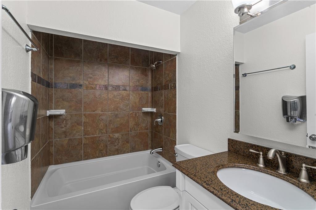 1305 Main Street Bridgeville, PA 15017 - Photo 20 of 50 a bathroom with a granite countertop sink toilet and shower
