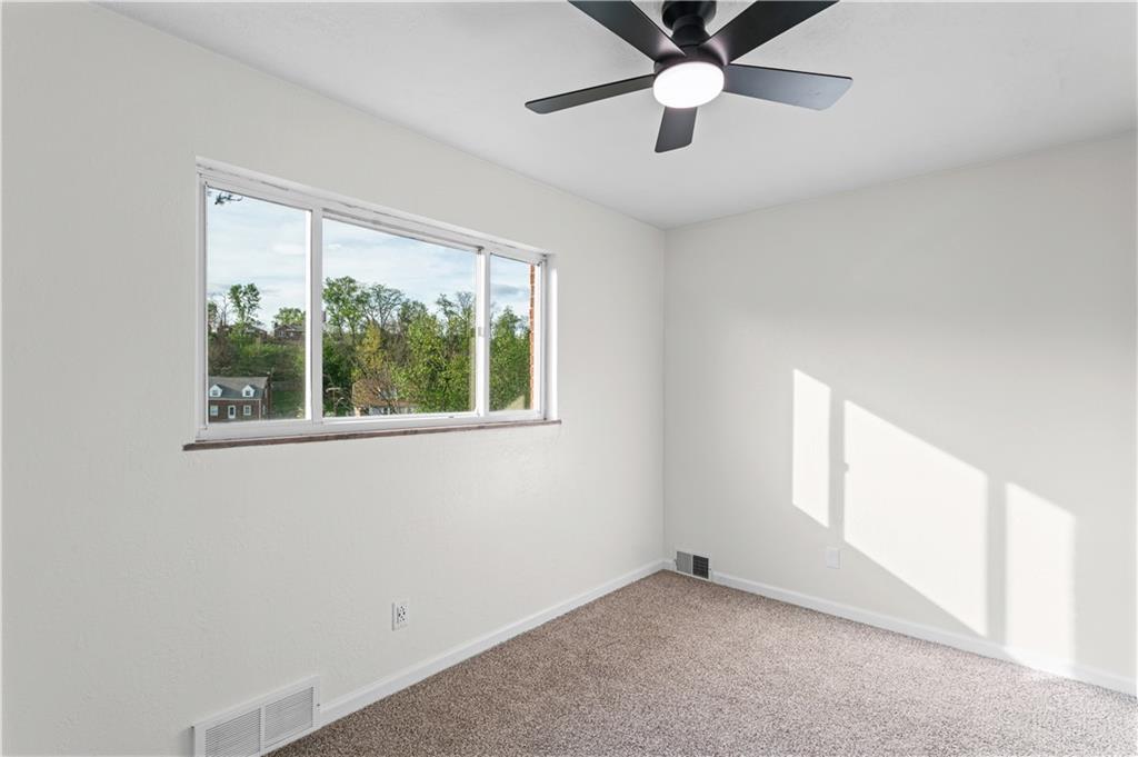 1305 Main Street Bridgeville, PA 15017 - Photo 23 of 50 an empty room with windows and fan