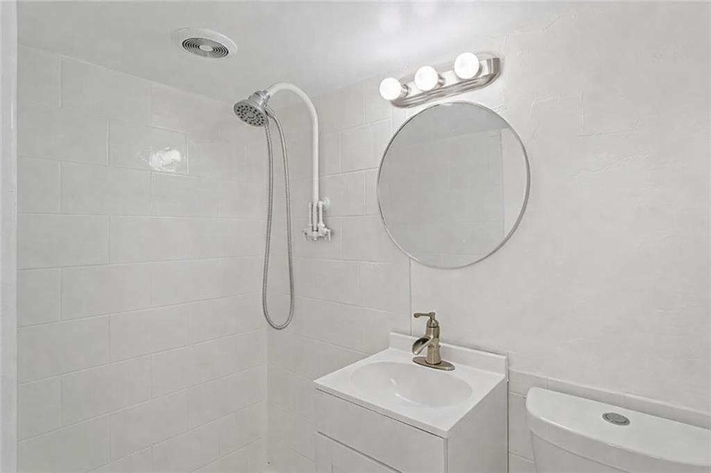 1305 Main Street Bridgeville, PA 15017 - Photo 37 of 50 a bathroom with a sink a mirror and a light fixture