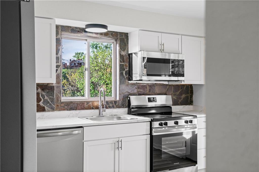 1305 Main Street Bridgeville, PA 15017 - Photo 4 of 50 a kitchen with stainless steel appliances a stove a sink and a microwave