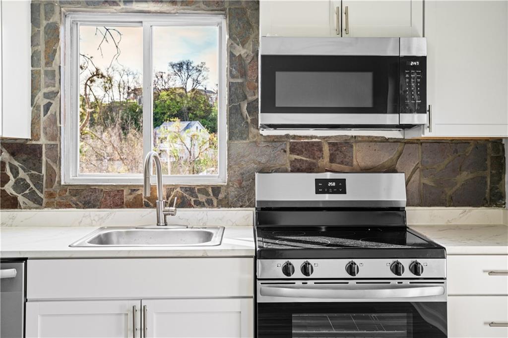 1305 Main Street Bridgeville, PA 15017 - Photo 7 of 50 a stove top oven sitting inside of a kitchen