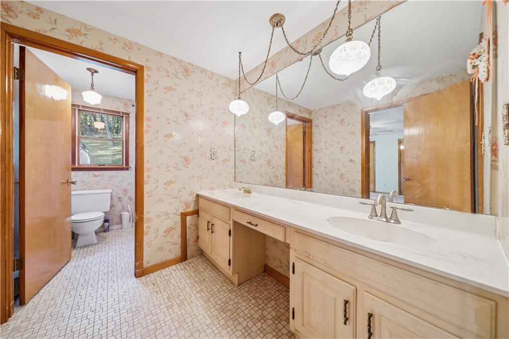 361 Maple Road Pittsburgh, PA 15239 - Photo 25 of 38 a spacious bathroom with a double vanity sink a toilet and a large mirror