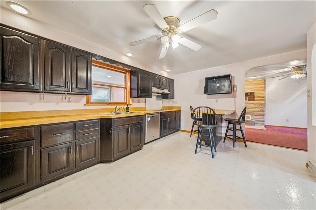 361 Maple Road Pittsburgh, PA 15239 - Photo 8 of 38 a kitchen with stainless steel appliances granite countertop a stove top oven a sink a dining table and chairs with wooden floor