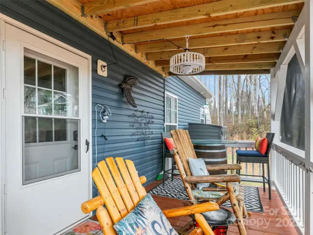 a view of a patio with table and chairs with wooden floor and fence