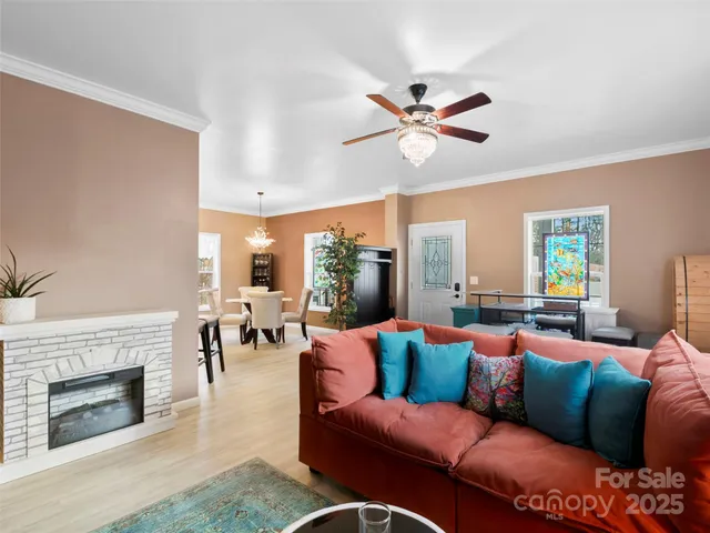 a living room with furniture a fireplace and a large window