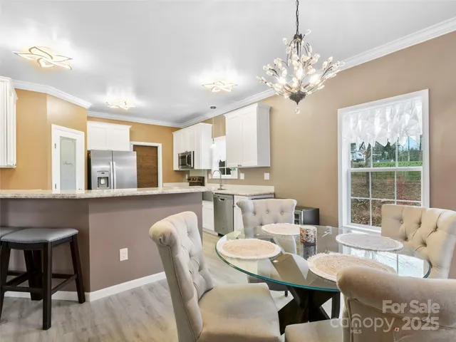 a living room with furniture a chandelier and a dining table