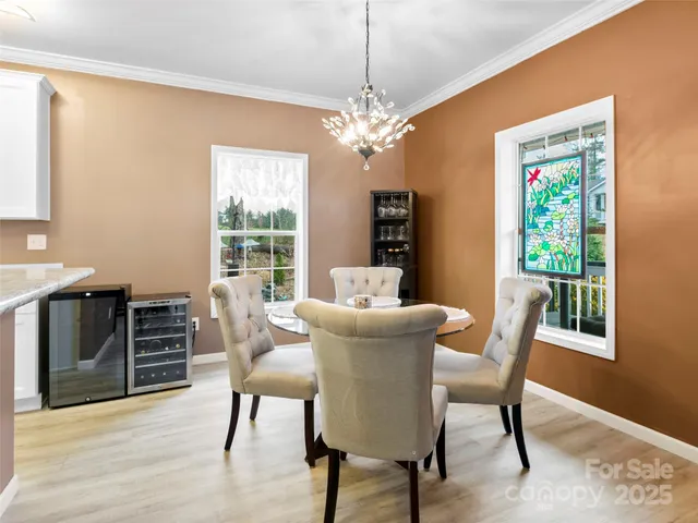 a dining room with furniture a chandelier and wooden floor