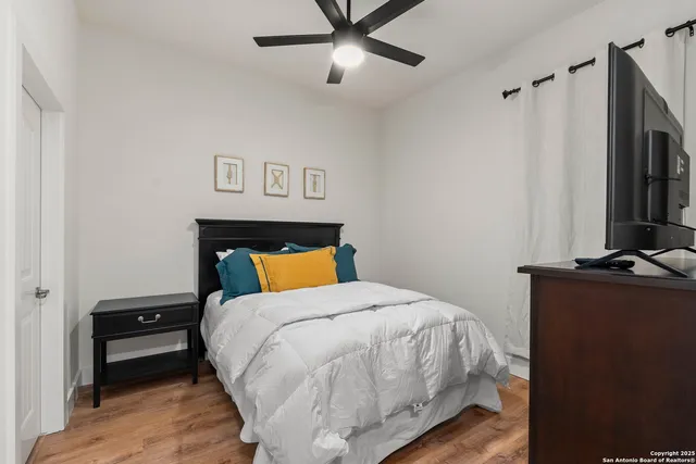 a bedroom with a bed and a flat tv screen on a dresser