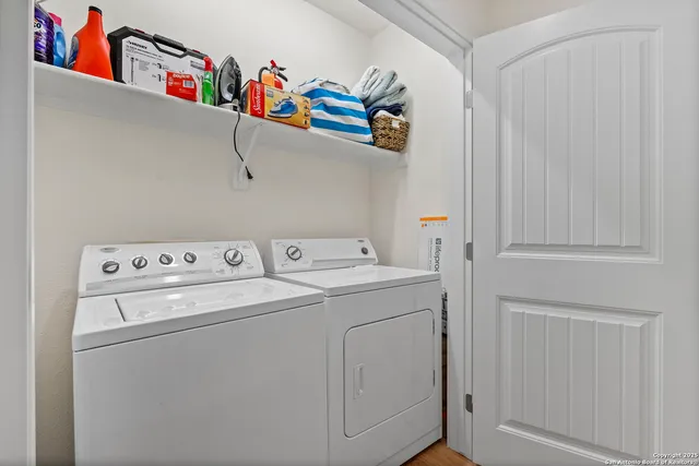 a view of a white building among the street and tall buildings