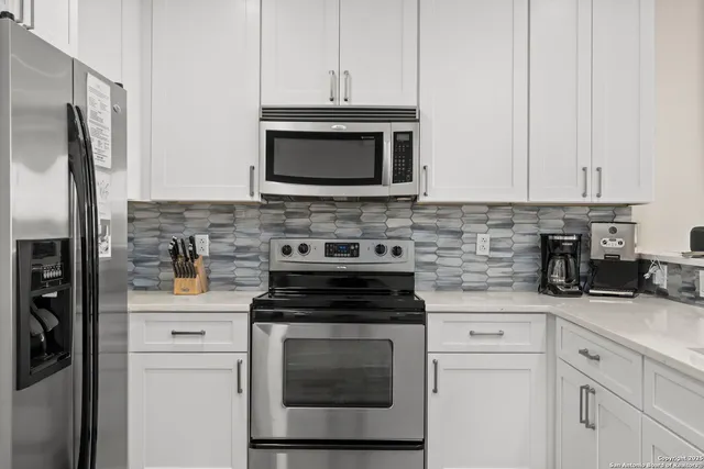 a kitchen with cabinets stainless steel appliances and a sink