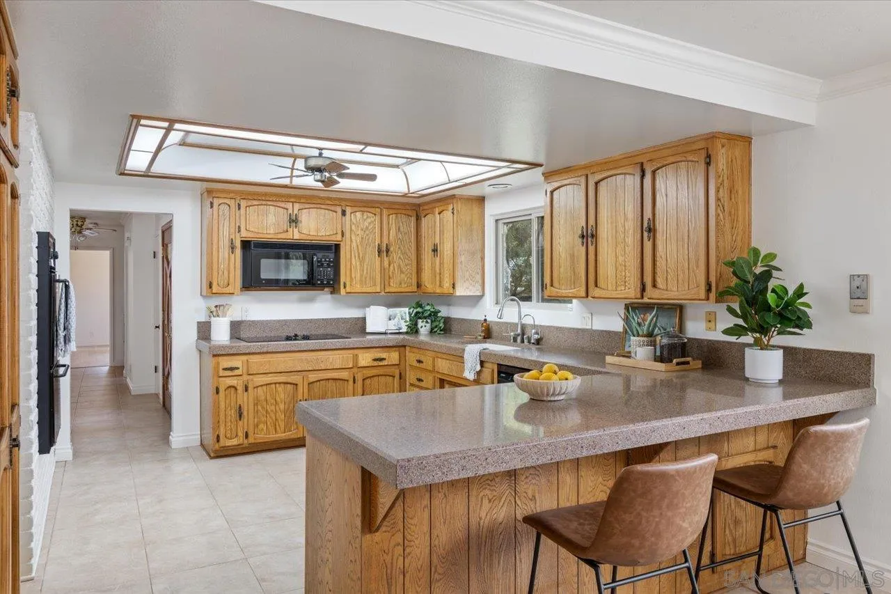 1786 Lorry Lane Escondido, CA 92029 - Photo 15 of 39 a kitchen with a table chairs sink and cabinets