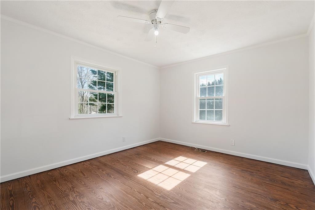 173 Winndale Road Dallas, GA 30157 - Photo 13 of 23 an empty room with wooden floor chandelier fan and windows