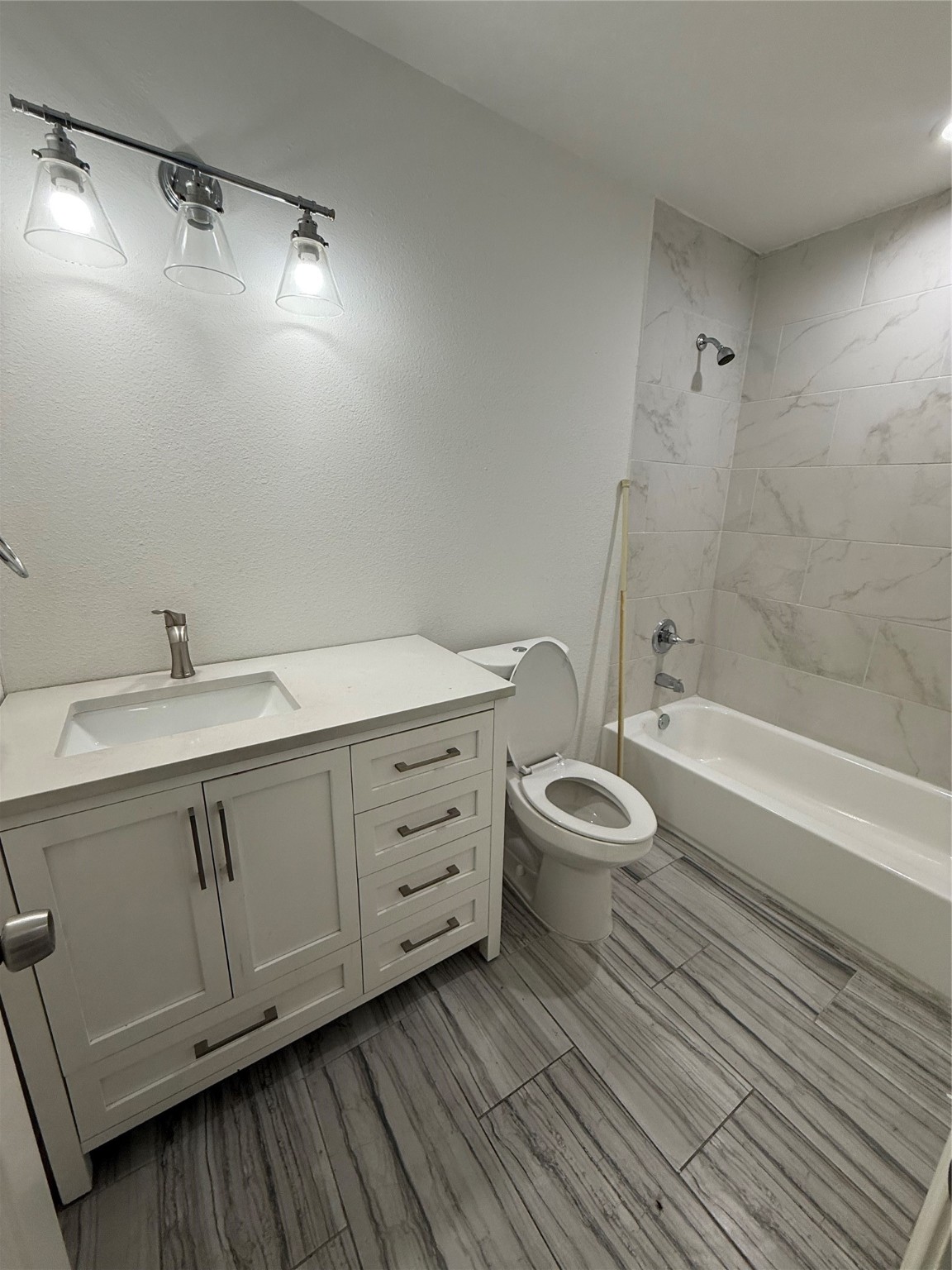 4707 Mallow Street, Unit B Houston, TX 77033 - Photo 4 of 16 a bathroom with a granite countertop sink toilet a mirror and shower