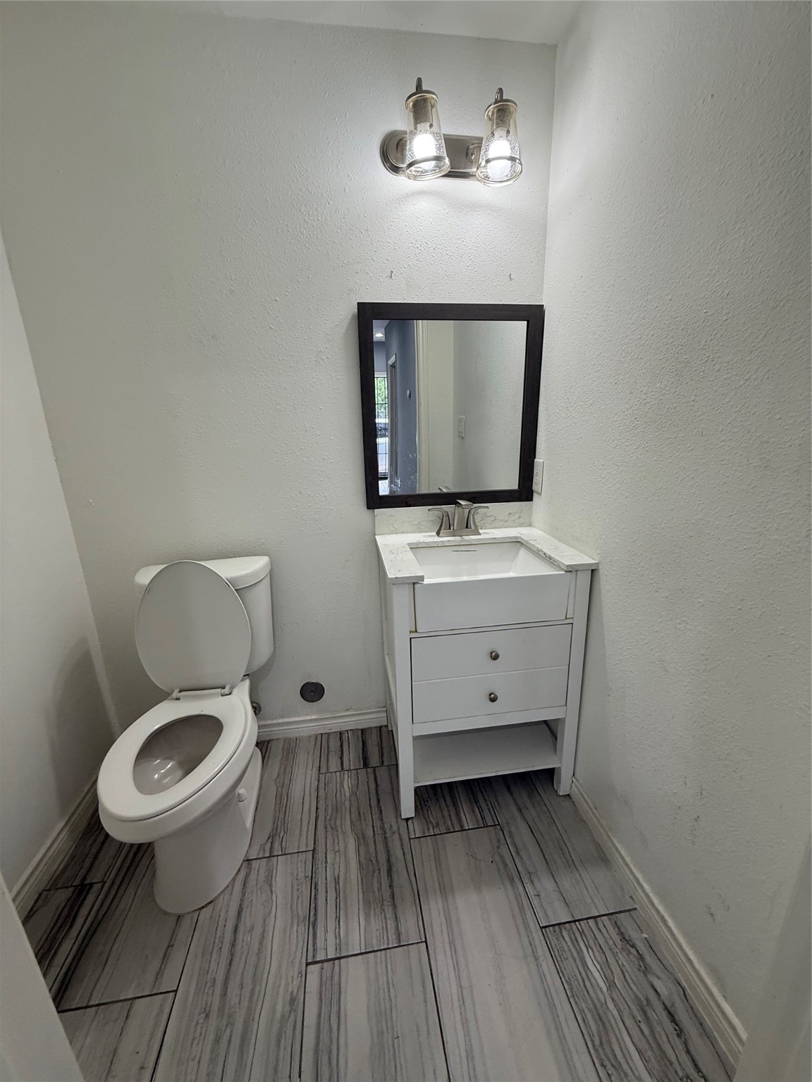 4707 Mallow Street, Unit B Houston, TX 77033 - Photo 6 of 16 a bathroom with a toilet sink and mirror