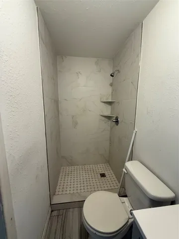 a white toilet sitting next to a shower
