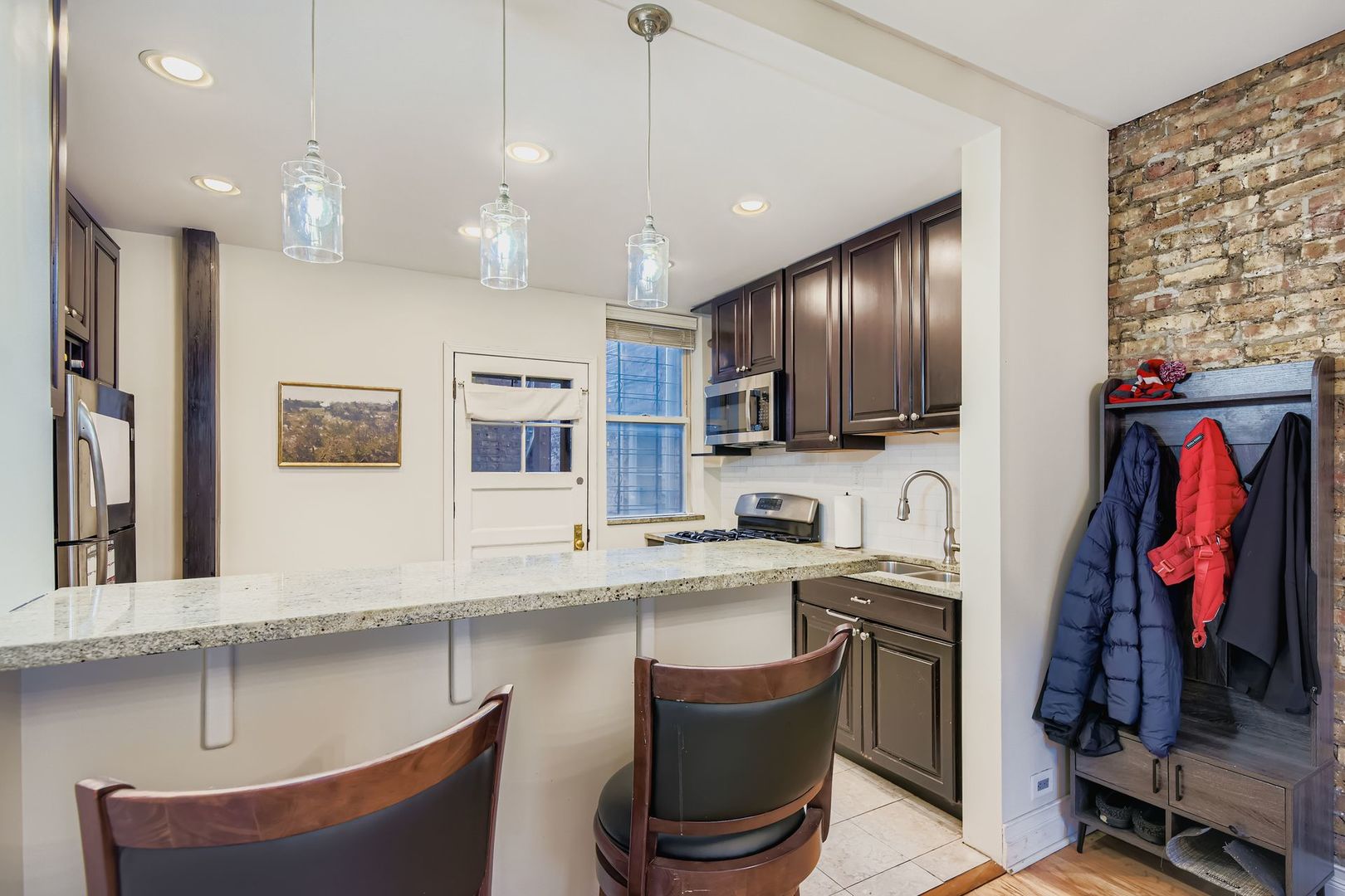 539 West Addison Street, Unit 2N Chicago, IL 60613 - Photo 15 of 23 a kitchen with stainless steel appliances granite countertop a sink dishwasher a stove and a refrigerator with wooden floor