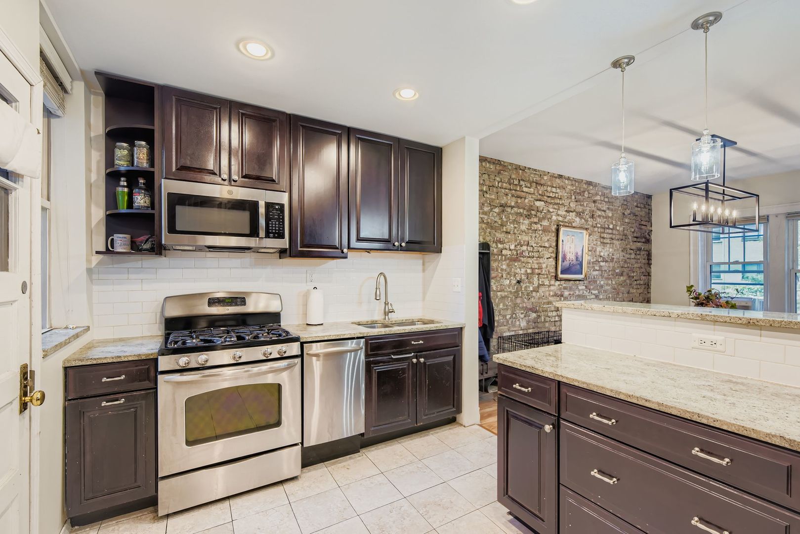 539 West Addison Street, Unit 2N Chicago, IL 60613 - Photo 20 of 23 a kitchen with granite countertop wooden cabinets stainless steel appliances and a window