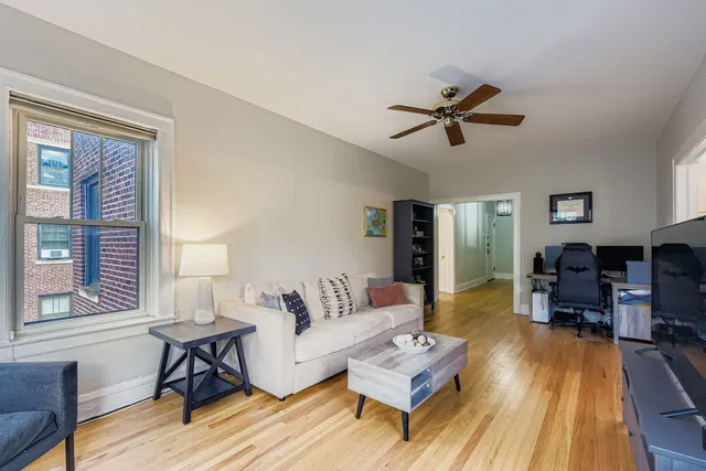 a living room with furniture flat screen tv and a large window