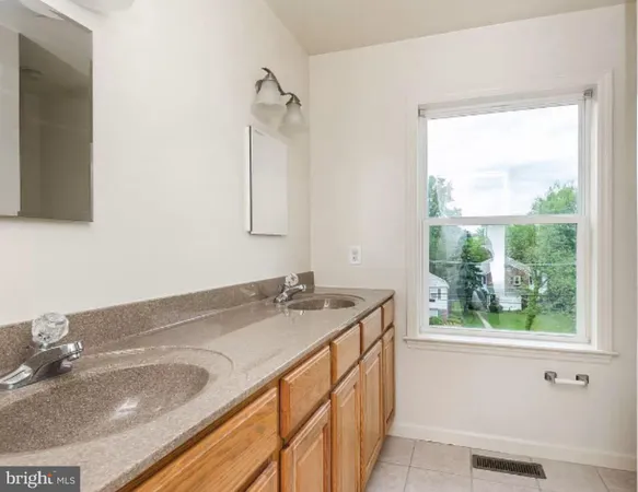 a bathroom with a granite countertop sink and a window