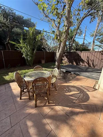 a view of a backyard with table and chairs and a large tree