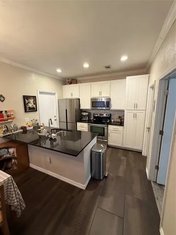 a kitchen with stainless steel appliances kitchen island granite countertop a refrigerator and a stove top oven