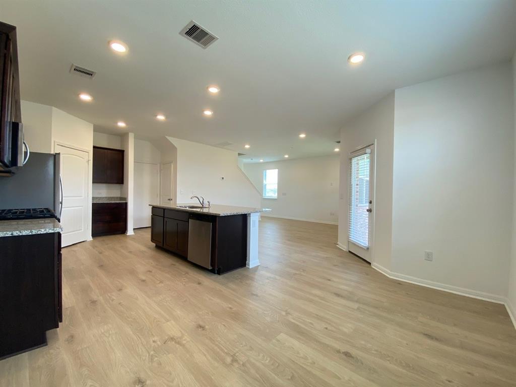 225 Saide Street Georgetown, TX 78626 - Photo 8 of 22 a large hall with stainless steel appliances kitchen island a large counter top and a wooden floor