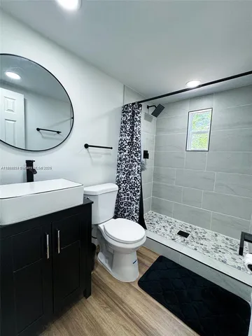 a bathroom with a sink toilet a shower and a mirror