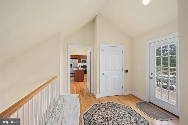 a view of a hallway with wooden floor and closet
