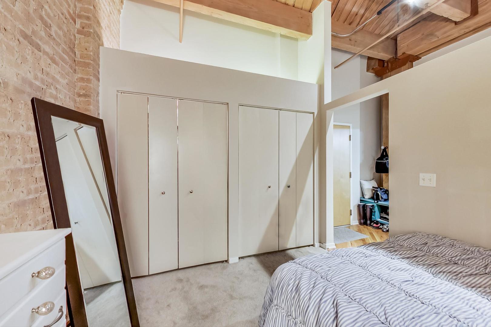 1040 West Adams Street, Unit 220 Chicago, IL 60607 - Photo 11 of 27 a bedroom with a bed and a mirror