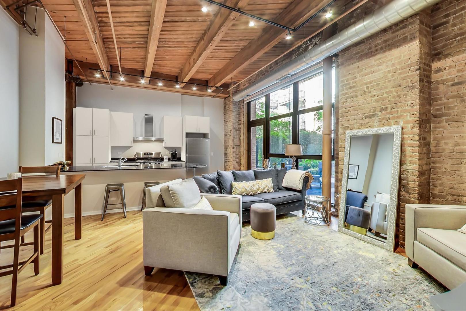 1040 West Adams Street, Unit 220 Chicago, IL 60607 - Photo 2 of 27 a living room with furniture and a view of kitchen