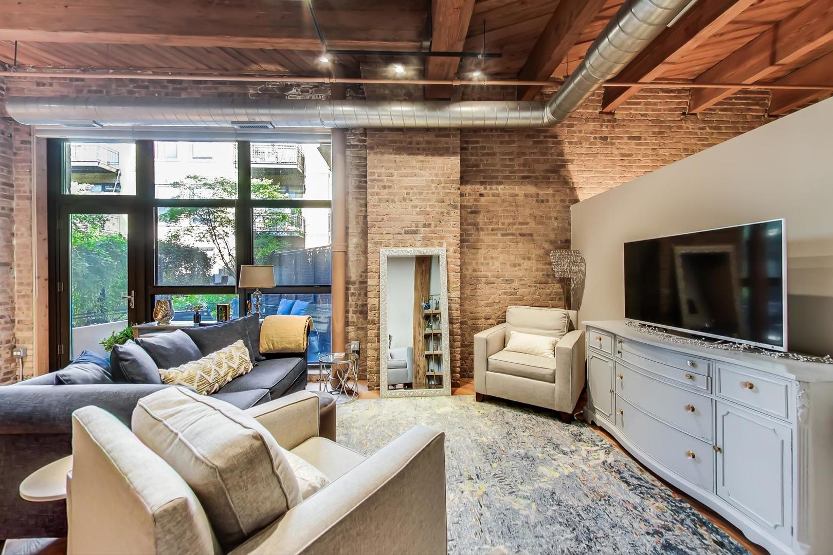 1040 West Adams Street, Unit 220 Chicago, IL 60607 - Photo 3 of 27 a living room with furniture and a flat screen tv