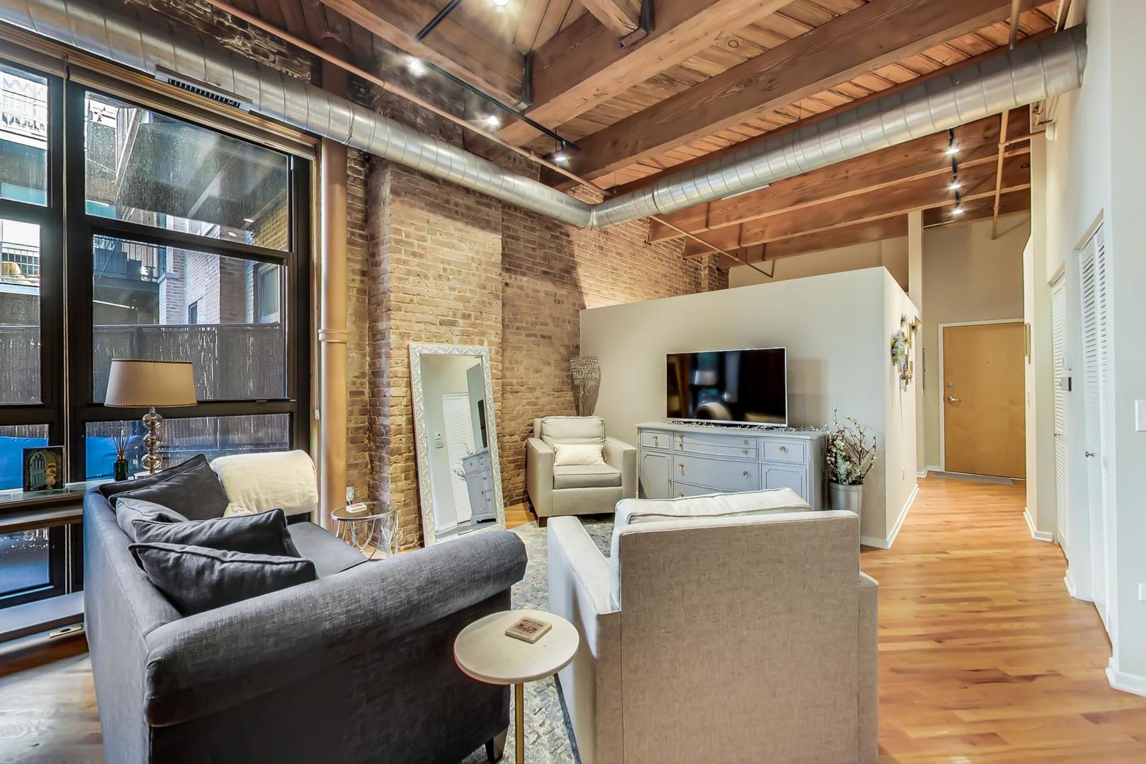 1040 West Adams Street, Unit 220 Chicago, IL 60607 - Photo 4 of 27 a living room with furniture and a flat screen tv