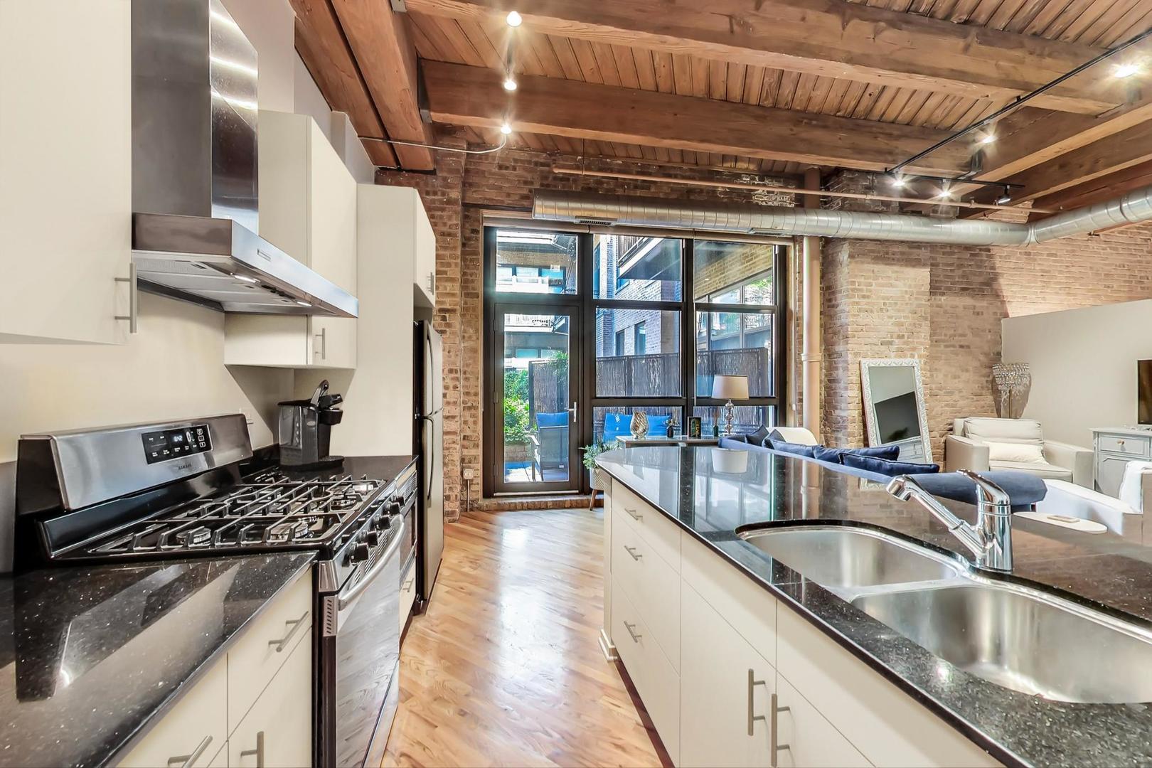 1040 West Adams Street, Unit 220 Chicago, IL 60607 - Photo 8 of 27 a kitchen with stainless steel appliances granite countertop a sink stove and cabinets