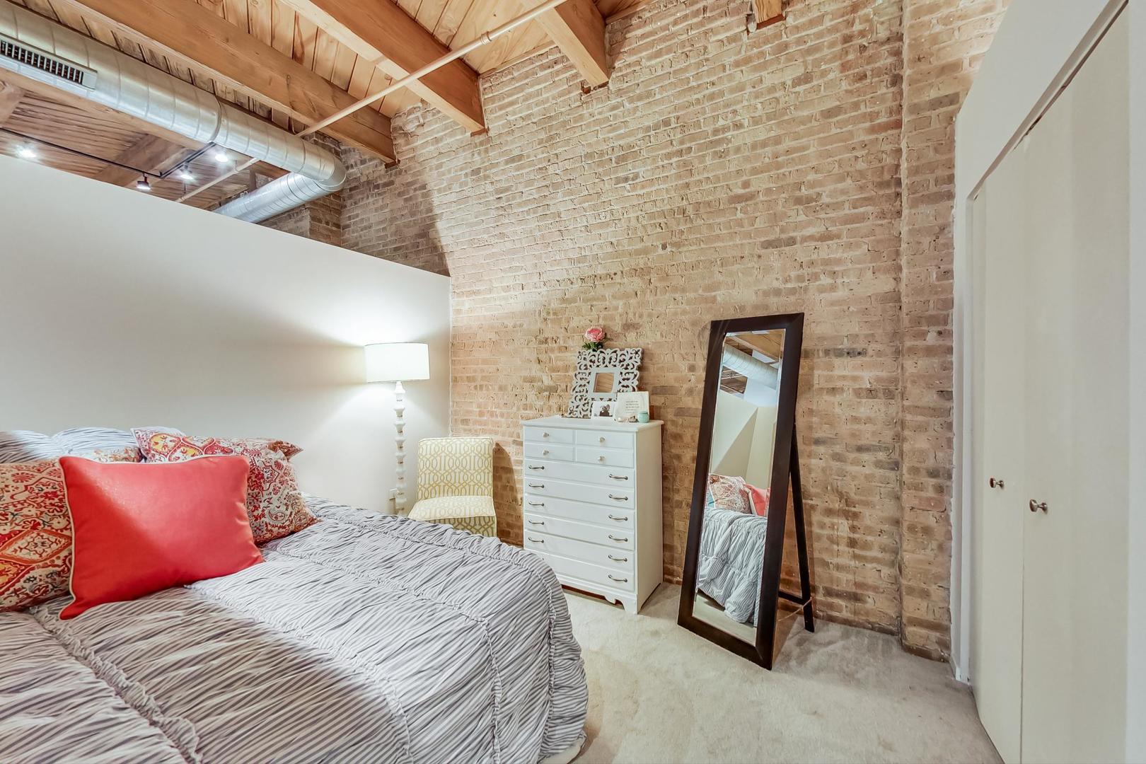 1040 West Adams Street, Unit 220 Chicago, IL 60607 - Photo 10 of 27 a bed room with a bed and a walk in closet