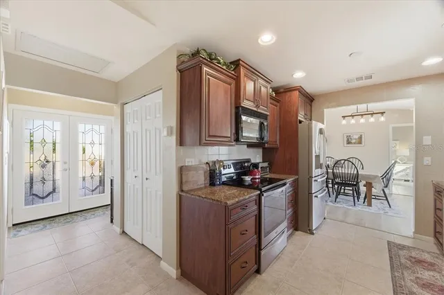 a kitchen with a refrigerator and a stove top oven