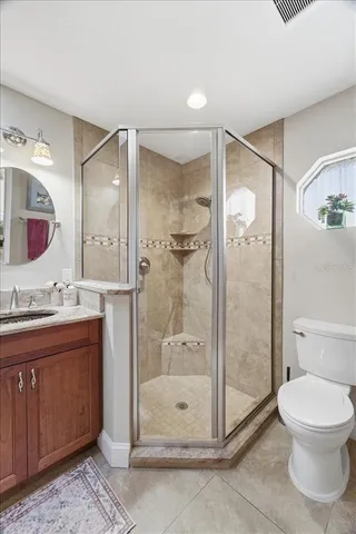 a bathroom with a shower sink mirror and toilet