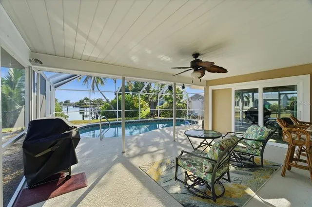 a living room with patio furniture and a floor to ceiling window