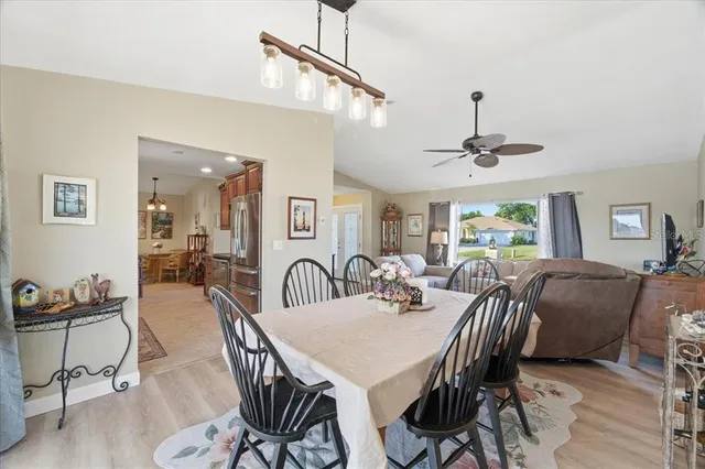 a view of a dining room and livingroom with furniture wooden floor a chandelier
