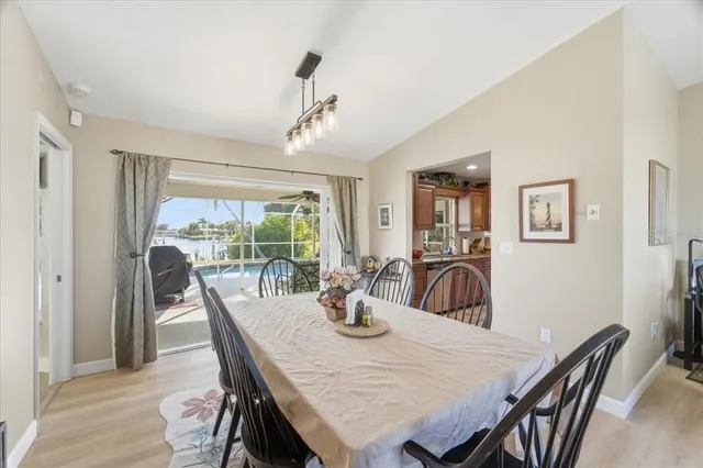 a dining room with furniture a large window and wooden floor