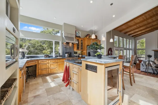 a large kitchen with kitchen island granite countertop a large counter top and stainless steel appliances