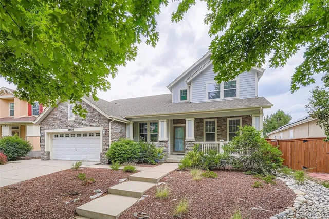 a view of a white house with a tree and plants
