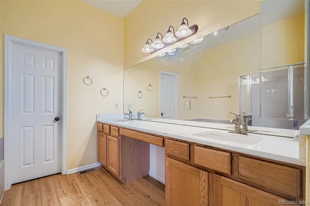 a spacious bathroom with a granite countertop sink a mirror and shower